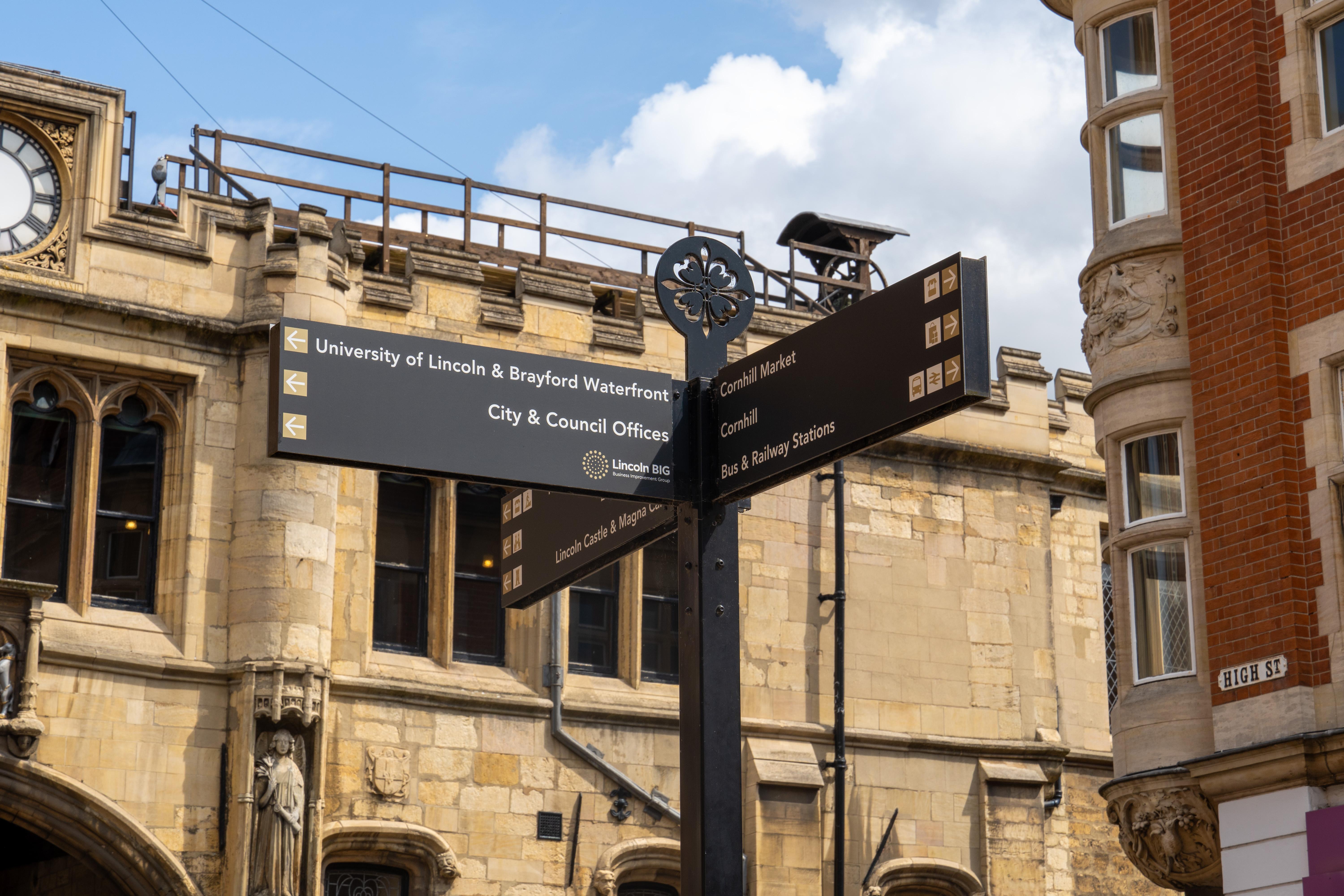 In Lincoln city centre, shows a sign which points at some of the main landmarks in Lincoln including the university, council offices, Cornhill market, Lincoln Castle and rail links.