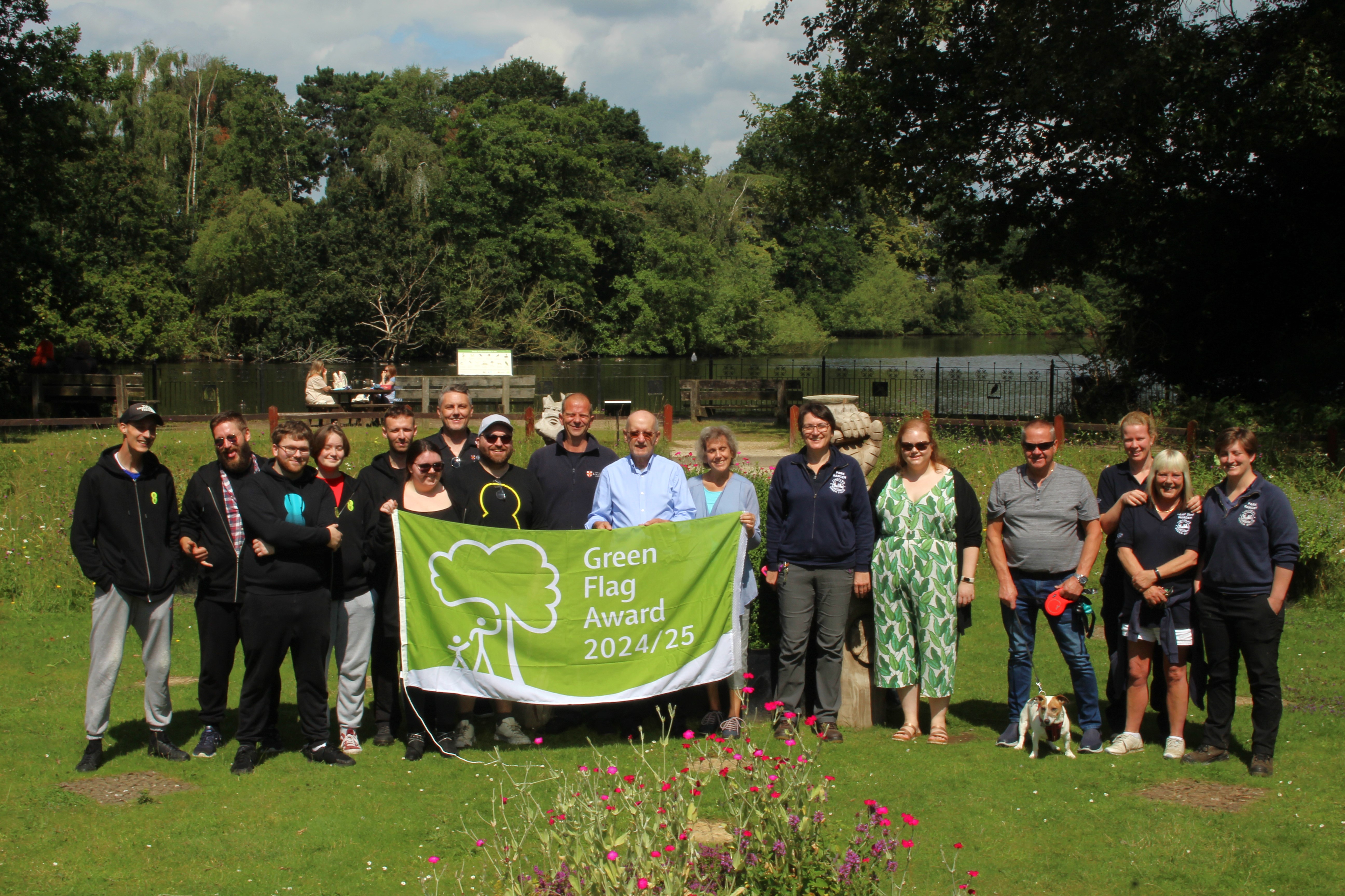Hartsholme employees and local council members stood in Hartsholme Park holding Green Flag
