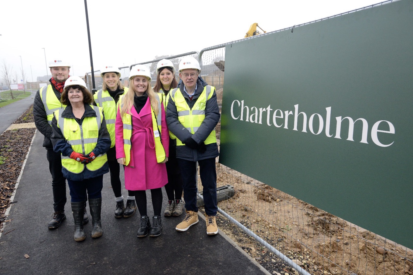 A group of six people all wearing PPE in front of the new Charterholme brand sign.