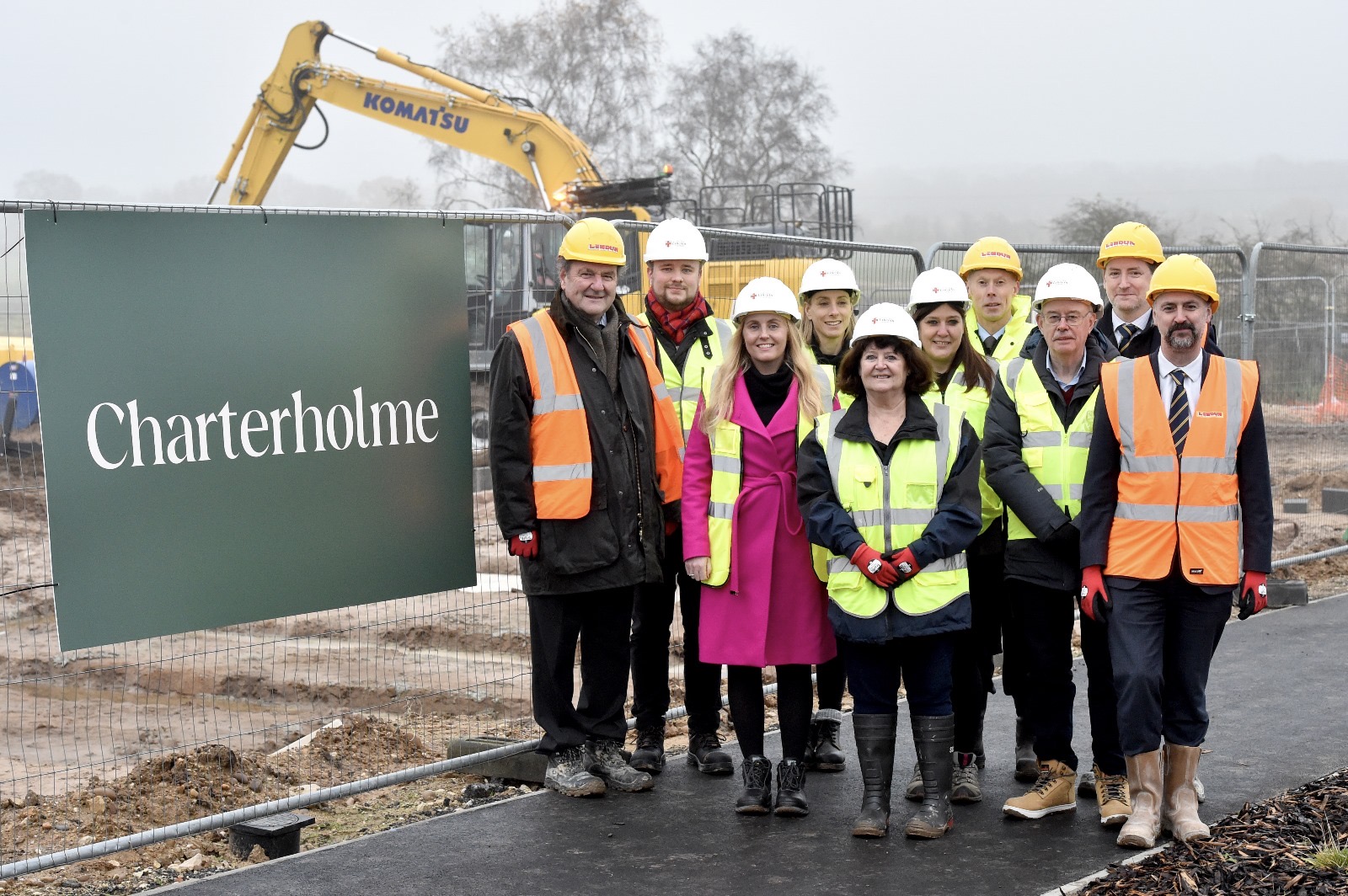 All of the key stakeholders stood in front of the new Charterholme logo on the site development.