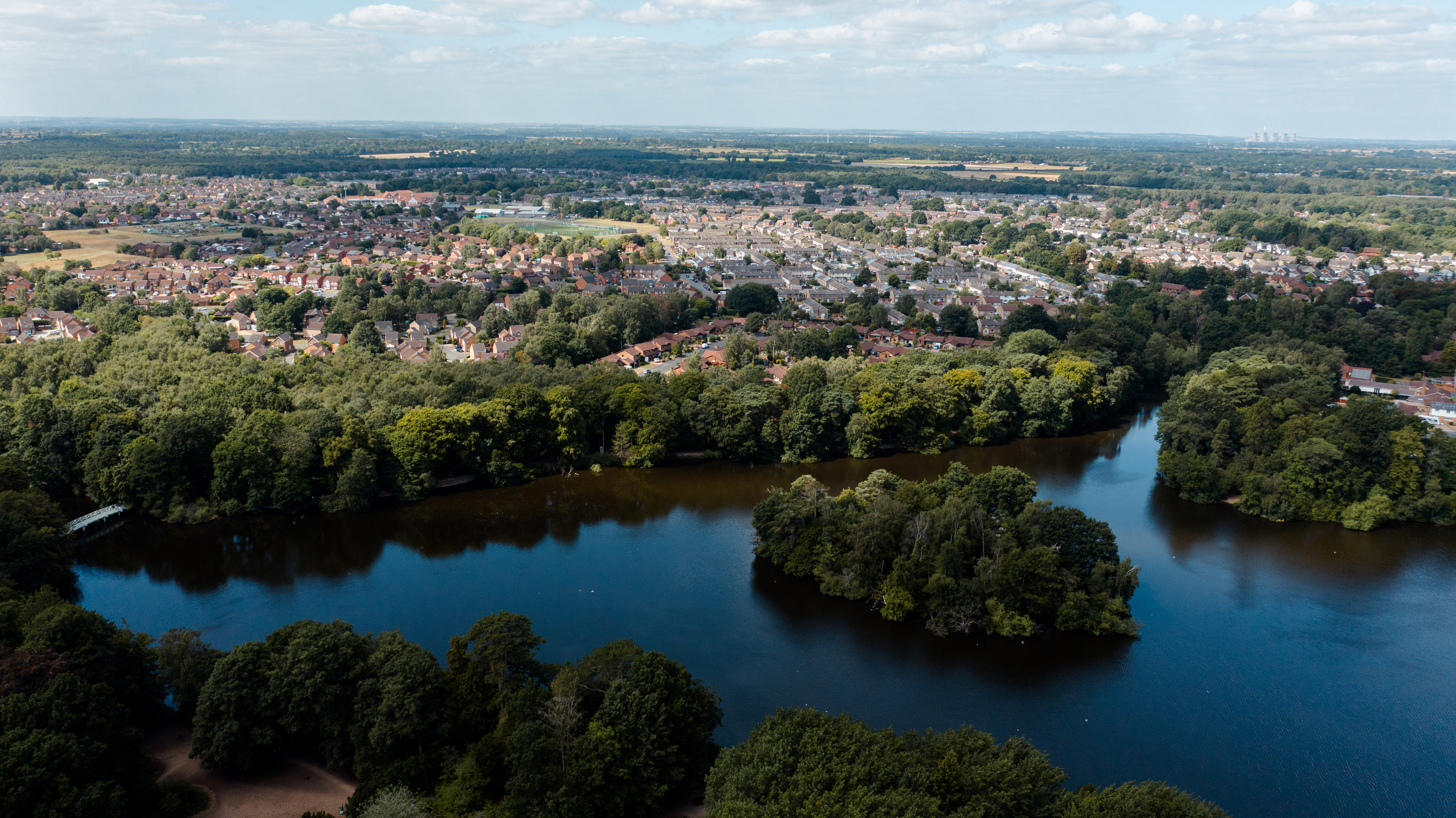 A drone photo of a lake in a park.